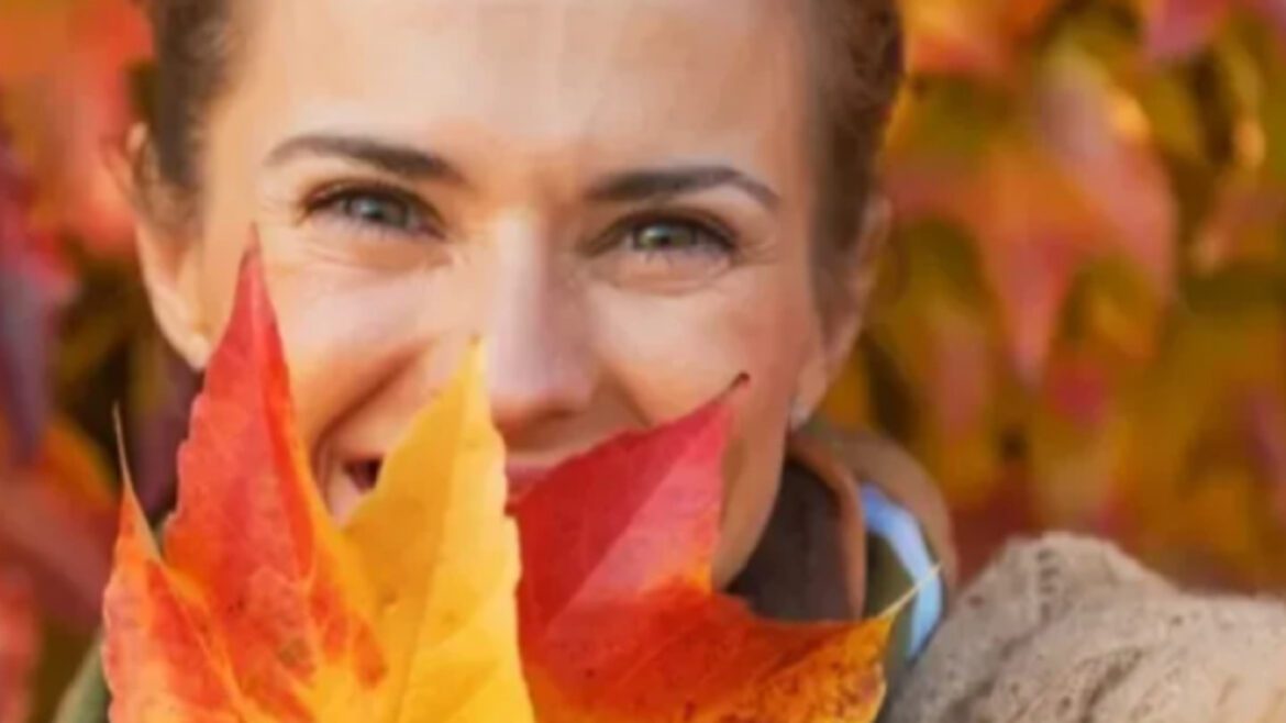 Besišypsanti moteris su spalvingais rudens lapais